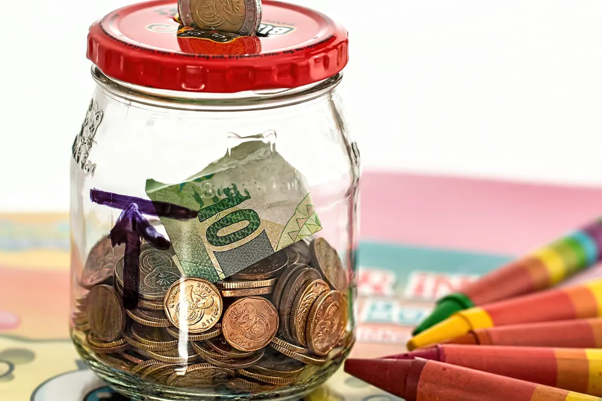 Bocal rempli de pièces de monnaie et d’un billet